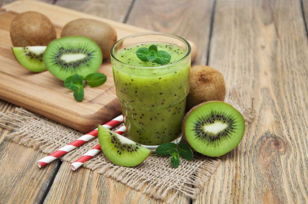 Kiwi interi e a fette e frullato di kiwi