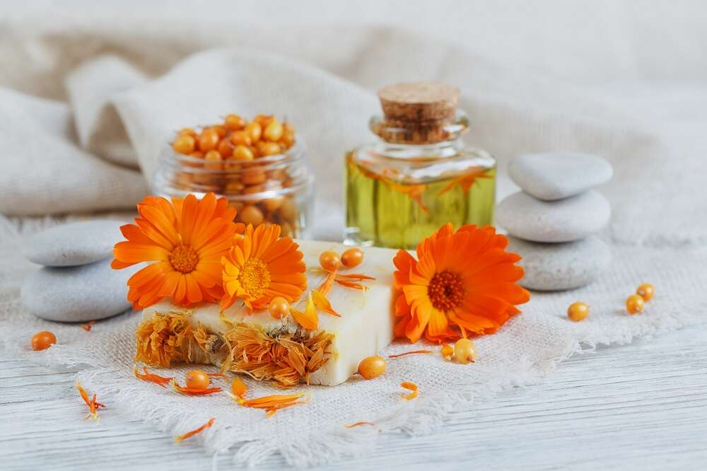 Fiori di calendula, bottiglie di olio e sapone